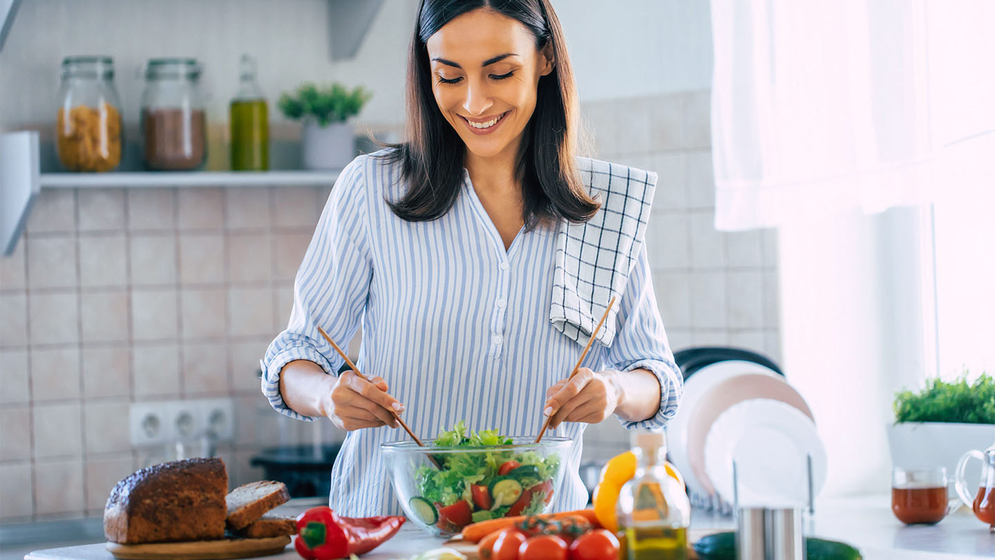 Mlada žena priprema zdrav obrok.
