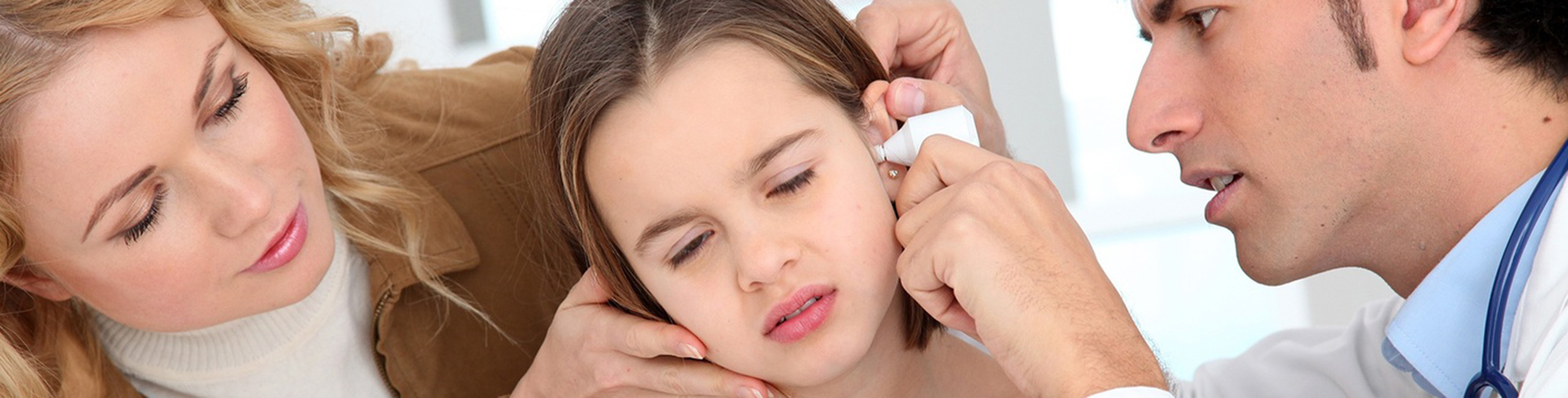 Djevojčica koju pregledava liječnik zbog upale uha.