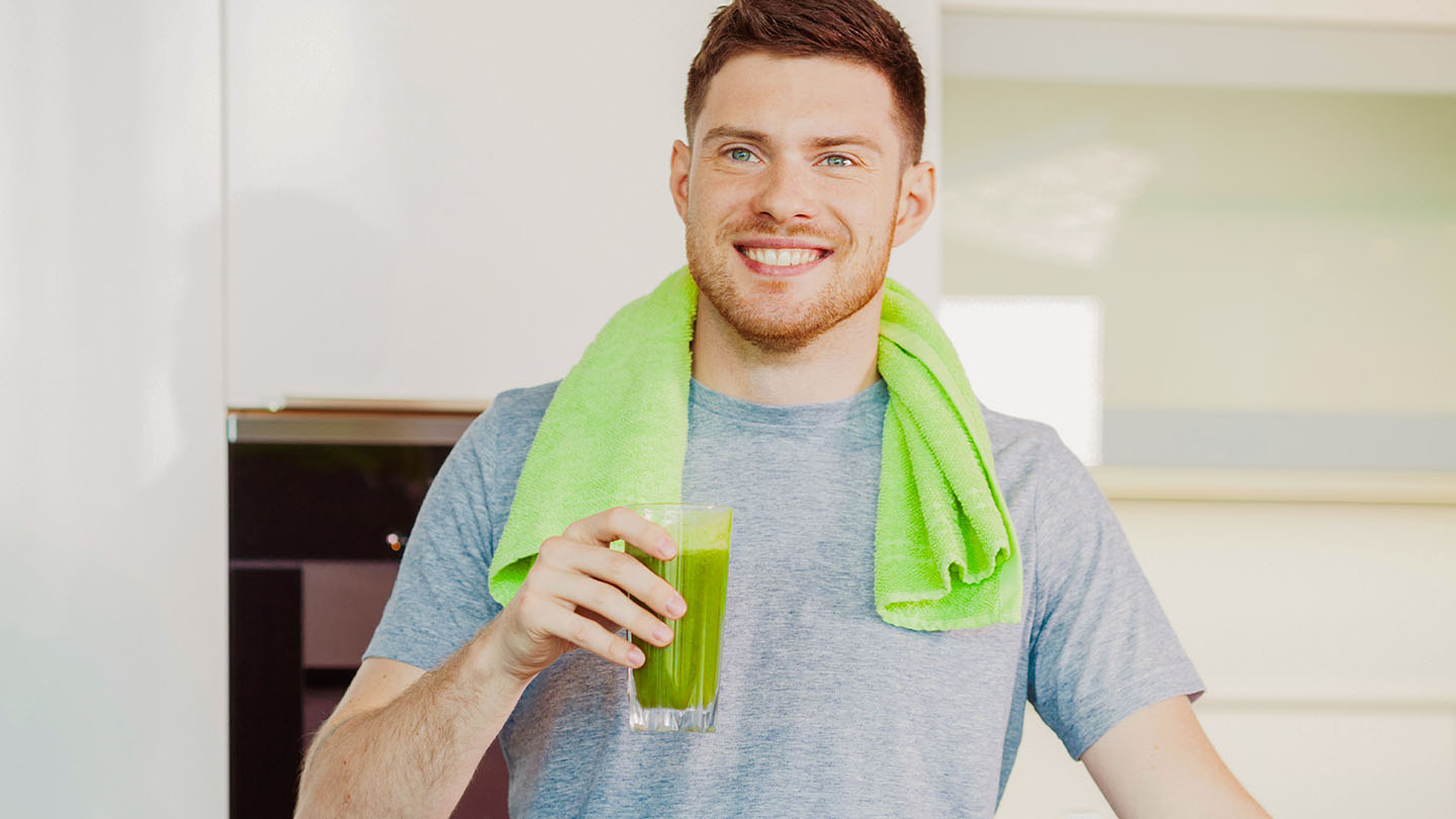 Muškarac uživa u zdravom zelenom smoothieju.