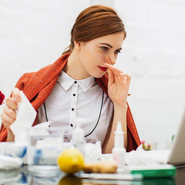 Bolesna žena s prehladom u uredu.