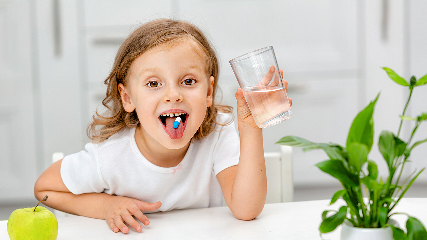 Djevojčica uzima dodatak prehrani za jačanje imunološkog sustava.