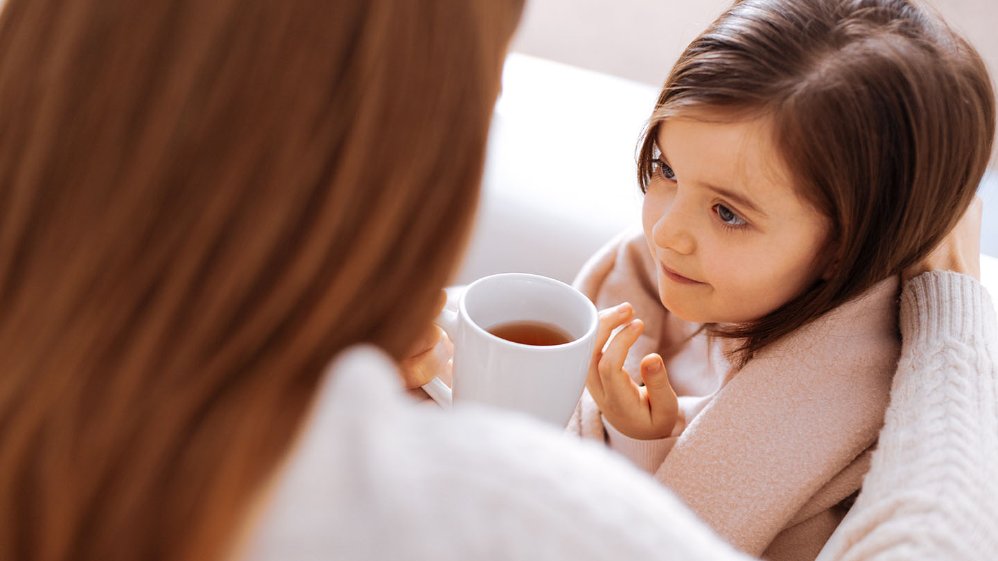 Majka nudi čaj svojoj kćeri koja ima gripu.