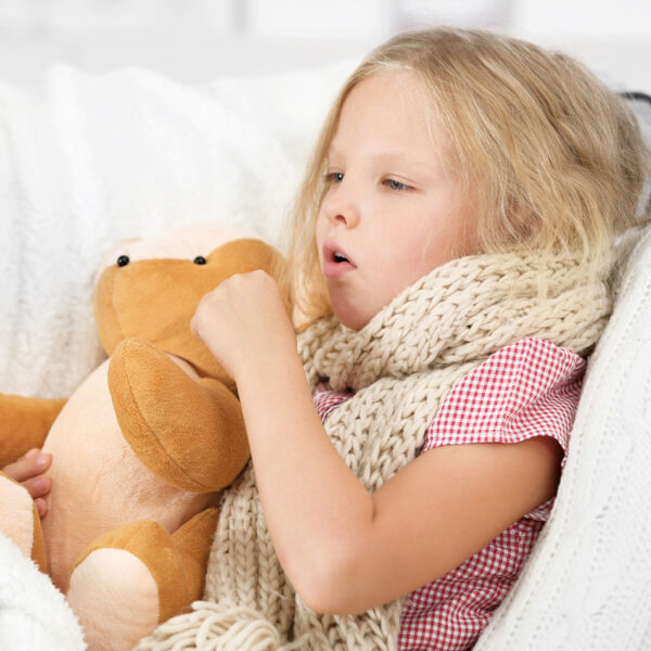 Bolesna djevojčica čvrsto se drži plišane igračke.