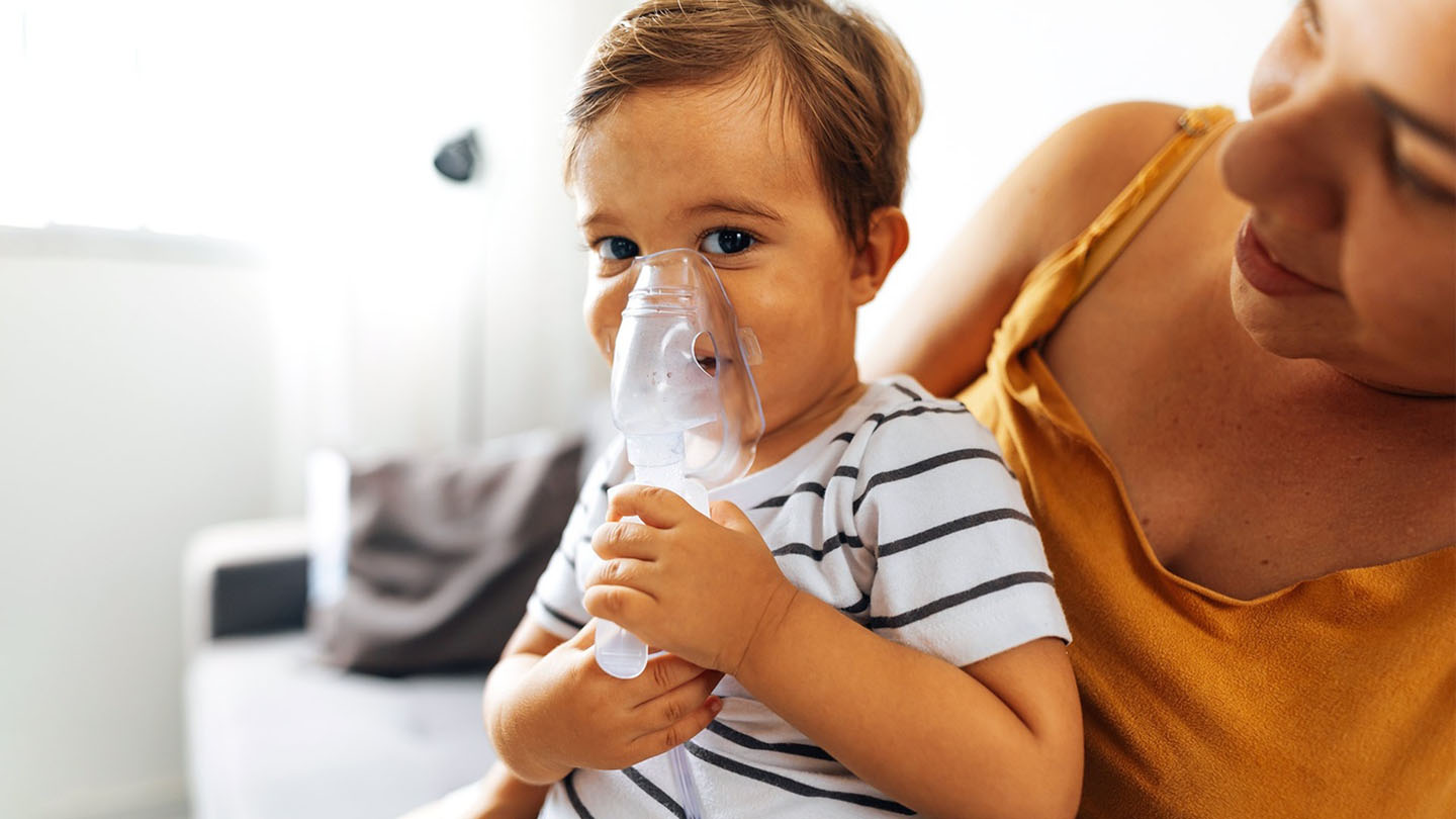 Dijete s maskom za disanje i njegova majka.