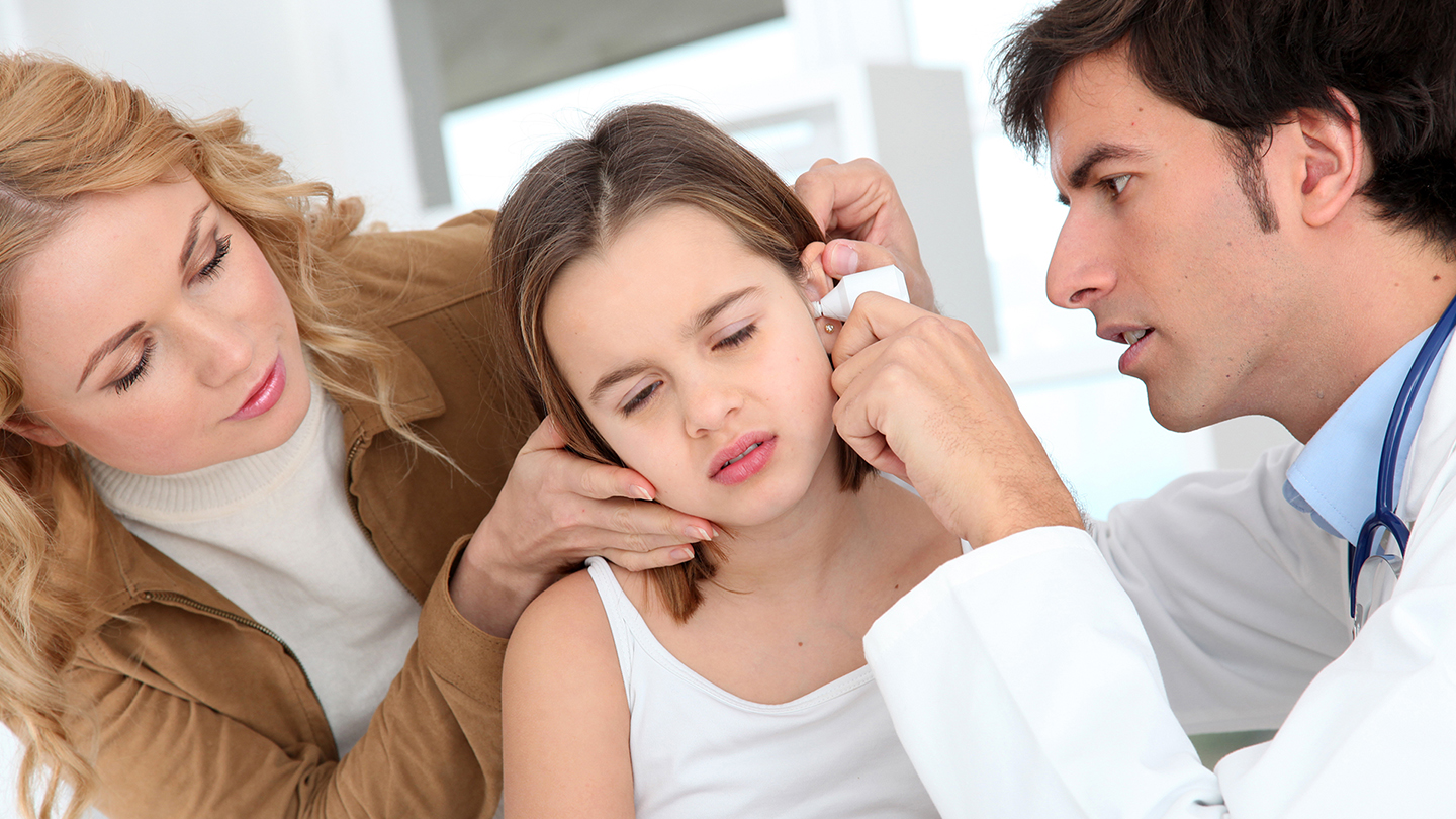 Liječnik pregledava djevojčino uho, infekciju uha.